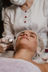 estudiante en proceso con paciente en taller de estética facial 