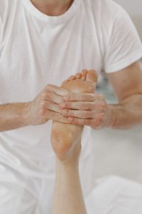 profesional tocando uno de los puntos de reflexología en el cuerpo